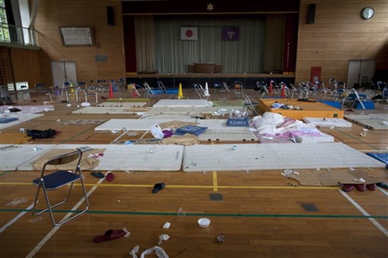 In this photo taken July 26, 2011, mats, bedding, chairs, slippers, empty bowls and cups lie on the floor of the gymnasium at Karino Elementary School which was used as an evacuation shelter in the town of Namie, Fukushima prefecture, northeastern Japan. Japan's system to forecast radiation threats was working from the moment its nuclear crisis began. As officials planned a venting operation certain to release radioactivity into the air, the system predicted the elementary school would be directly in the path of the plume emerging from the tsunami-hit Fukushima Dai-Ichi nuclear plant. But the prediction helped no one. Nobody acted on it. The school, just over six miles (10 kilometers) from the plant, was not immediately cleared out. Quite the opposite. It was turned into a temporary evacuation center. (AP Photo)